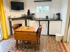 una piccola cucina con tavolo e sedie in legno di Le Clos de la Gravette a Bessières