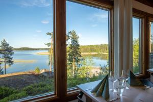 a dining room with large windows looking out onto a lake at Poukama in Porvoo