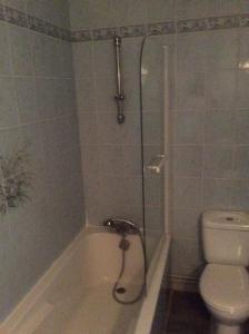La salle de bains est pourvue d'une douche, de toilettes et d'une baignoire. dans l'établissement Le Trianon, à Hesdin