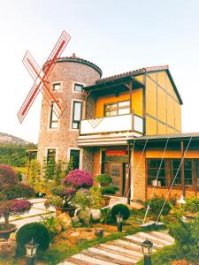 a house with a windmill in front of it at Wang Lao Ye B&B in Jinhu