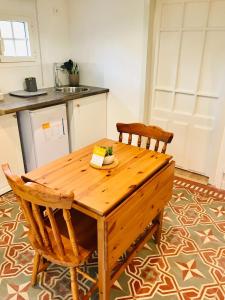 una cucina con un tavolo di legno e due sedie di Le Clos de la Gravette a Bessières Altre 15 foto