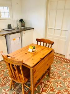 a kitchen with a wooden table and two chairs at Le Clos de la Gravette in Bessières