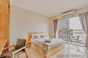 a hotel room with a bed and a balcony at Lemonade Phuket Hotel -SHA Plus in Chalong