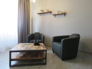 een woonkamer met 2 stoelen en een salontafel bij Champagne Gilmaire-Etienne in Binson-et-Orquigny