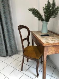 a desk with a chair and a vase with a plant at Gelsomino Rooms Ravello in Ravello