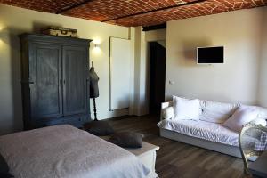 sala de estar con cama y sofá en La Crusetta, en San Marzano Oliveto