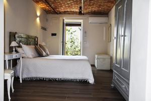 a bedroom with a white bed and a window at La Crusetta in San Marzano Oliveto