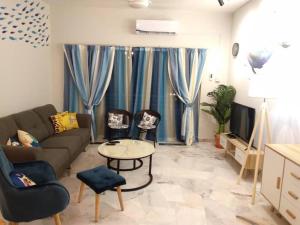 - un salon avec un canapé, des chaises et une télévision dans l'établissement The Whale - Bayview - Pool open, à Port Dickson
