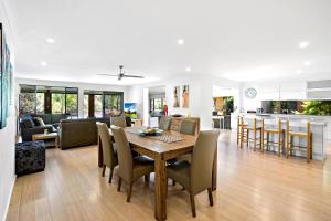 a dining room and living room with a table and chairs at Bonville on Bonville in Sawtell