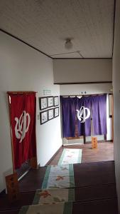 a room with purple and white curtains and a bed at Shukubo Daishinbo in Tsuruoka