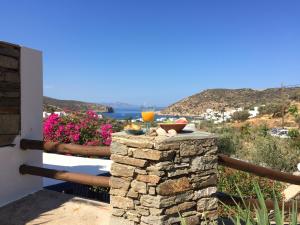 a table with a glass of orange juice on a stone wall at Villa Costa Studios in Vathi