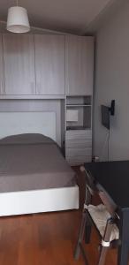 1 dormitorio con cama, escritorio y silla en Le Ninfe Bed and Breakfast, en Anzio