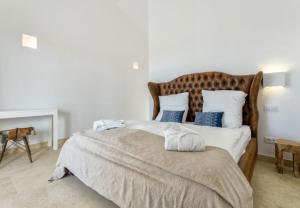 a bedroom with a large bed with blue pillows at Finca El Idilio in Ses Salines