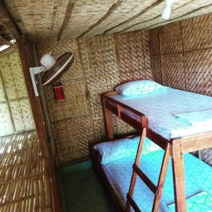 a small room with a bunk bed and a table at Gigante Island Homestay - Balay sa Gigante in Carles
