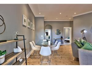 een eetkamer en woonkamer met een tafel en stoelen bij Central Green Point Apartment in Kaapstad +15 foto's