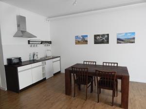 eine Küche mit einem Tisch und Stühlen im Zimmer in der Unterkunft FREE Apartment - Am Kurpark in Bad Urach