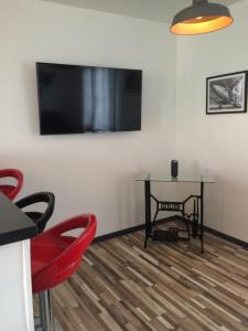 Zimmer mit einem Tisch und einem TV an der Wand in der Unterkunft Le Clément'Inn in Noyers-sur-Cher