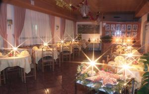 un comedor con mesas con luces. en Albergo Eden, en Passo del Tonale