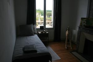 a bedroom with a bed and a window with a ladder at QUAI SOUCHET in Libourne