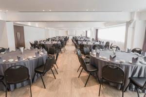 a conference room with tables and chairs and a room with at Thomson Hotel Huamark in Bangkok