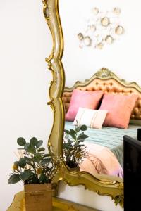 uno specchio d'oro seduto su un tavolo accanto a un letto di Appartamento Il Campo a Siena