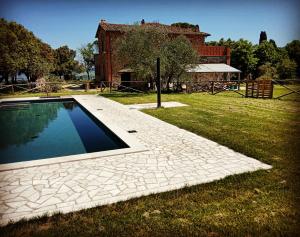 ein Schwimmbad in einem Hof neben einem Haus in der Unterkunft Agriturismo Riparossa in Allerona