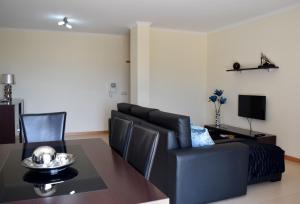 uma sala de estar com uma mesa e um sofá em Apartamento T2 Vista Mar na Nazaré