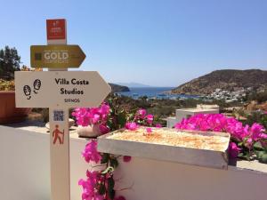 a sign that reads villa corrina studies ships with pink flowers at Villa Costa Studios in Vathi