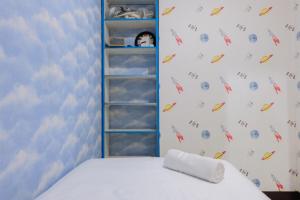 a bedroom with a bed and a book shelf at 2BR Apartment at 18th Floor Great Western By Travelio in Tangerang +11 photos