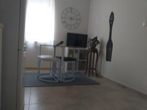 sala de estar con mesa, sillas y reloj en Made in You - Oporto Guesthouse, en Oporto