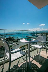 een balkon met een tafel en stoelen en uitzicht op de oceaan bij Manzoni Elements in Milazzo