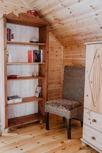 a room with a chair and a book shelf at Tumiło in Dziwnów