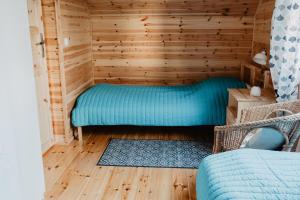 a sauna with a blue bed in a wooden room at Tumiło in Dziwnów