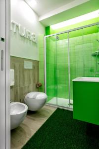 a green bathroom with a toilet and a shower at Manzoni Elements in Milazzo +35 photos