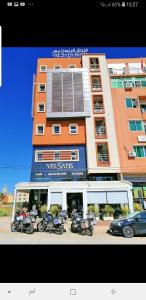 een gebouw met motoren die ervoor geparkeerd staan bij Hotel VELSATIS in Beni Mellal