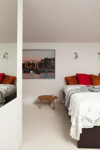 2 camas en una habitación blanca con una mesa entre ellas en Houseboat Ark van Amstel, en Ámsterdam