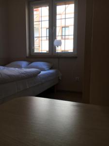 a room with two beds and a window at Plażowa klatka 5P -wewnętrzne podwórko- Apartament 5P, piętro I in Rowy