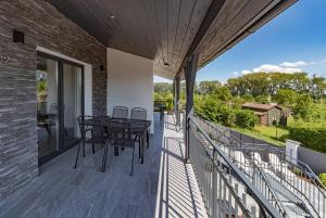 a patio with tables and chairs on a balcony at Villa Wine House in Hrušovany nad Jevišovkou