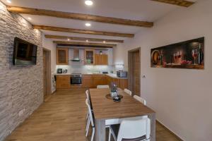 a kitchen and dining room with a wooden table and chairs at Villa Wine House in Hrušovany nad Jevišovkou