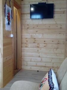 a corner of a room with a wall with a television at Timber House in Tivat