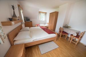 ein Schlafzimmer mit einem großen Bett, einem Tisch und Stühlen in der Unterkunft Tourist Farm Pr'Dovar in Cerklje na Gorenjskem