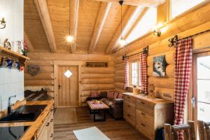 a log cabin kitchen with wooden walls and ceilings at Chalet Ellerbeck in Langdorf