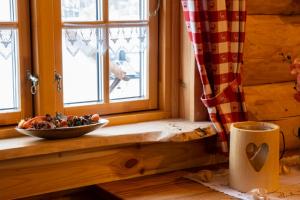 eine Schüssel Essen auf einem Fensterbrett mit einer Schale Obst in der Unterkunft Chalet Ellerbeck in Langdorf