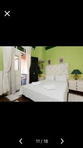 a bedroom with a white bed and a green wall at Villa Barchelona in Kallirákhi