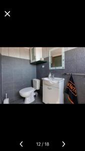 a bathroom with a white toilet and a sink at Villa Barchelona in Kallirákhi