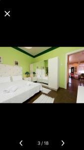 a bedroom with a white bed and a green wall at Villa Barchelona in Kallirákhi
