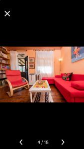 a living room with a red couch and a table at Villa Barchelona in Kallirákhi