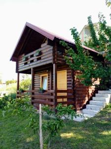 a small log cabin with a porch and stairs at Timber House in Tivat