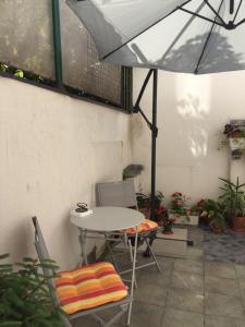 a table and chairs with an umbrella on a patio at Crown Street Garden Studio in Belgrade
