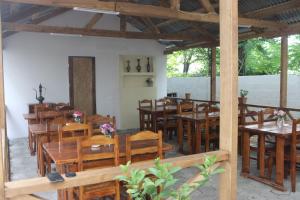 una sala da pranzo con tavoli e sedie in legno di Sofia House a Kobuleti